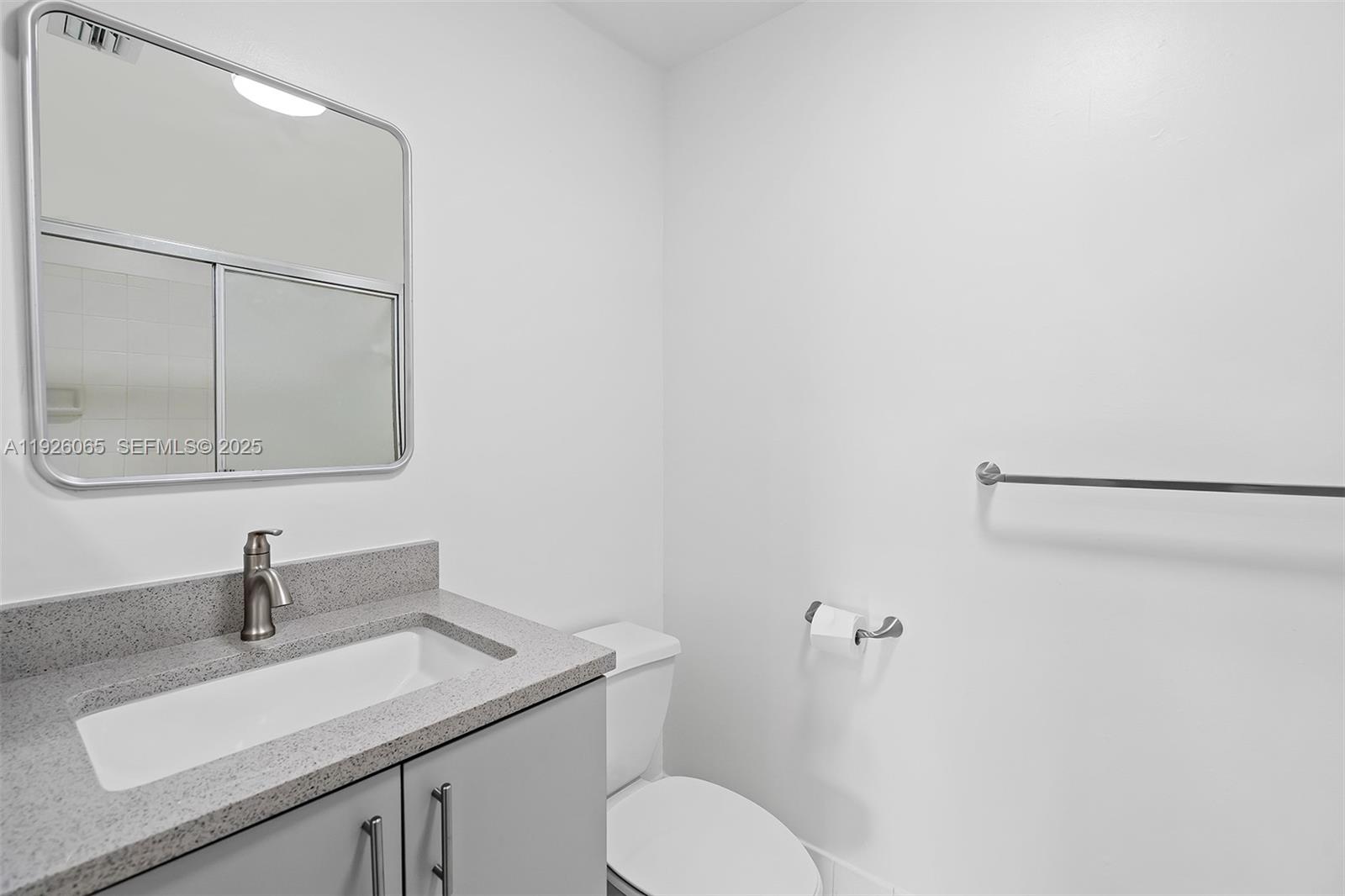 6992 Southwest 39th Street, Unit I302 Davie, FL 33314 - Photo 16 of 23 a bathroom with a toilet sink and mirror