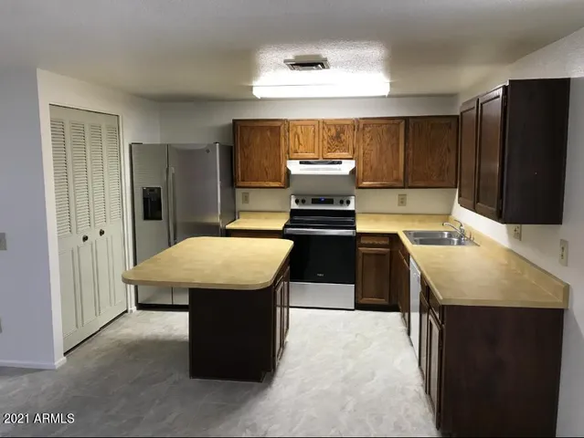 a kitchen with a sink a counter top space and stainless steel appliances