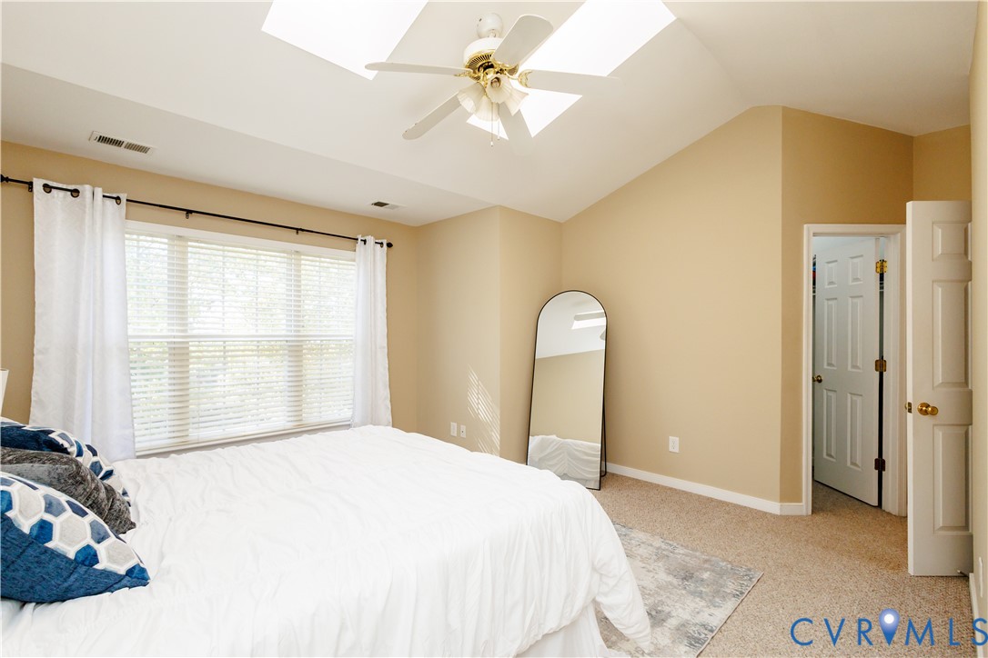 405 Hollybrook Ridge Lane Richmond, VA 23223 - Photo 20 of 37 a bedroom with a bed and a chandelier