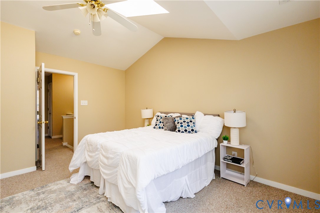 405 Hollybrook Ridge Lane Richmond, VA 23223 - Photo 22 of 37 a bedroom with a bed and a chandelier