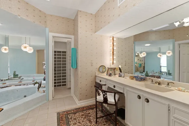 a bathroom with a sink a mirror and a clock on the dresser