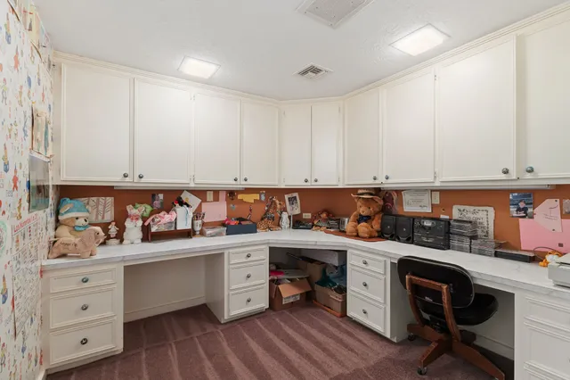 a spacious bedroom with a bed dresser and a chandelier