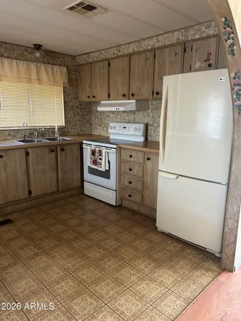 a kitchen with refrigerator and cabinets