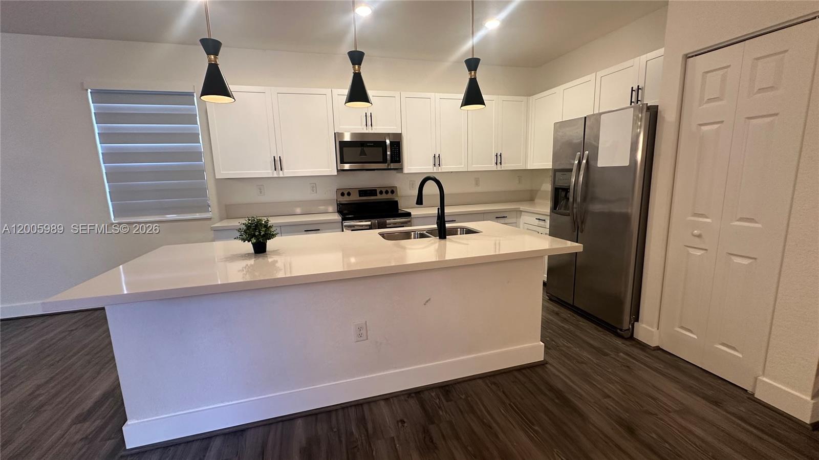 3423 West 110th Street Hialeah, FL 33018 - Photo 3 of 42 a kitchen with stainless steel appliances a sink a refrigerator a counter space and wooden floor