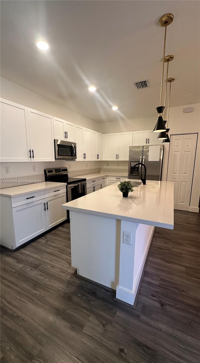 3423 West 110th Street Hialeah, FL 33018 - Photo 4 of 42 a room with stainless steel appliances kitchen island a sink a stove and cabinets