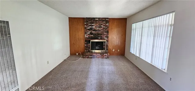 an empty room with fireplace and windows