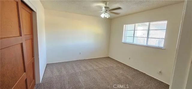 an empty room with windows and fan