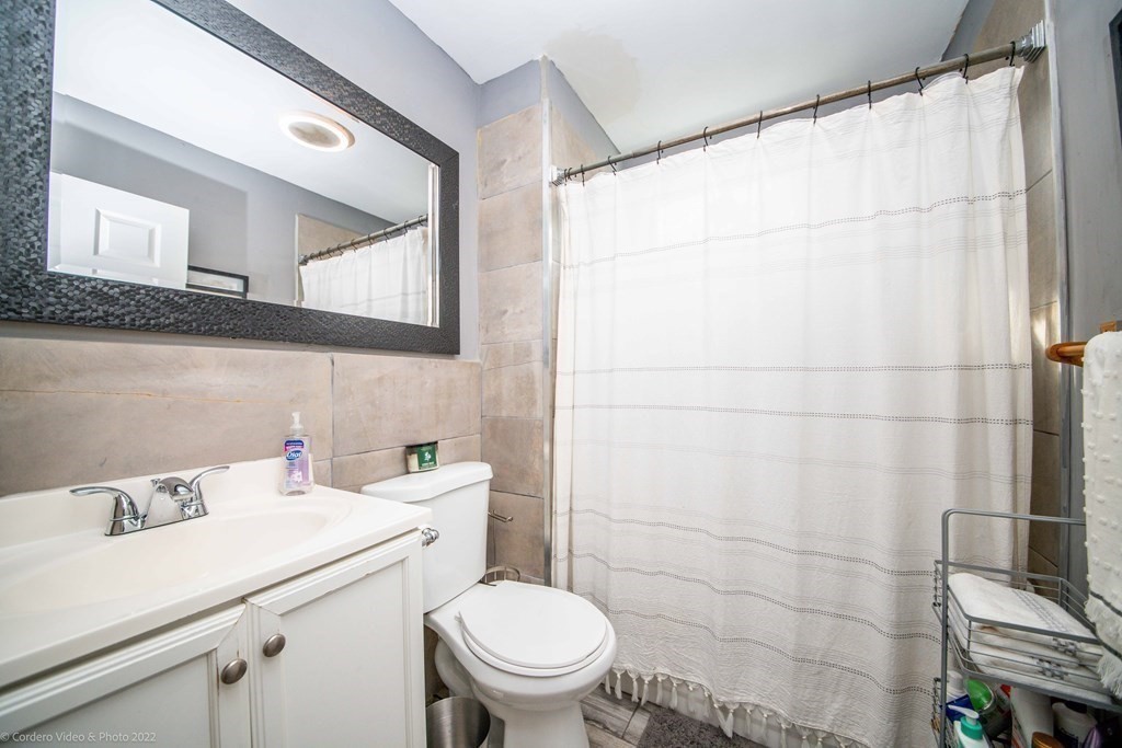 170 Buffinton Street Fall River, MA 02721 - Photo 11 of 38 a bathroom with a sink a toilet and a mirror