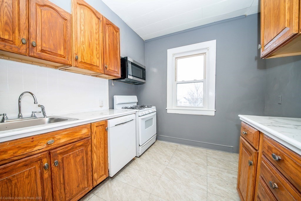 170 Buffinton Street Fall River, MA 02721 - Photo 23 of 38 a kitchen with granite countertop cabinets stainless steel appliances a sink and a window