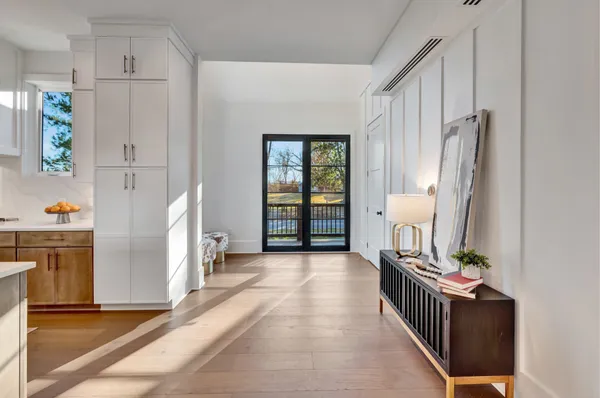 a kitchen with stainless steel appliances granite countertop a sink a stove a refrigerator and white cabinets with wooden floor