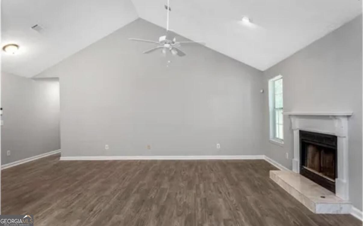956 Forest Path Stone Mountain, GA 30088 - Photo 2 of 11 wooden floor in an empty room with a fireplace