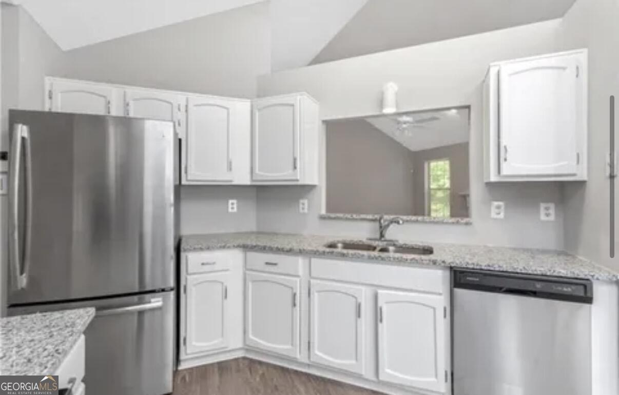 956 Forest Path Stone Mountain, GA 30088 - Photo 4 of 11 a kitchen with stainless steel appliances granite countertop a refrigerator sink and white cabinets
