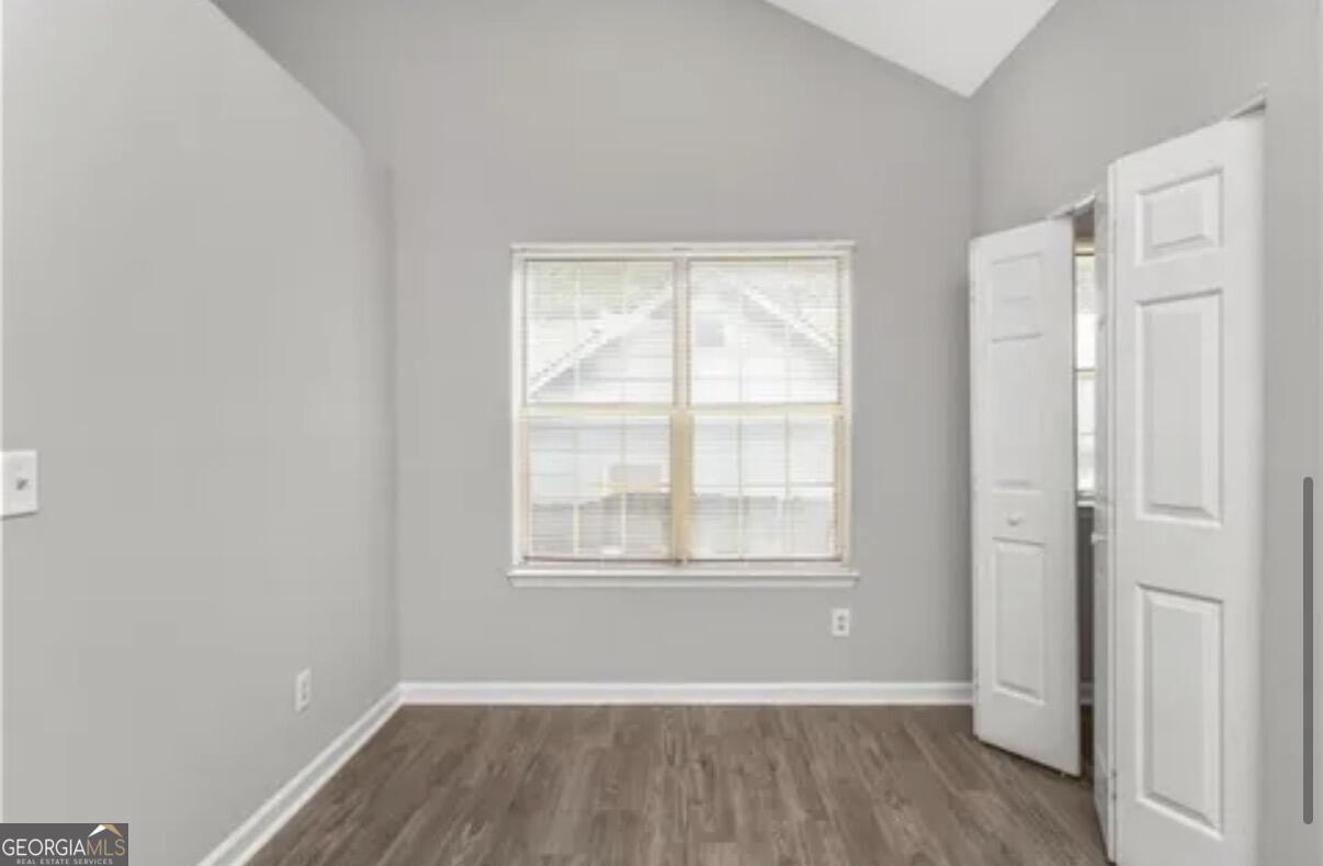 956 Forest Path Stone Mountain, GA 30088 - Photo 6 of 11 an empty room with wooden floor and windows