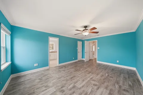 a view of a big room with wooden floor and windows