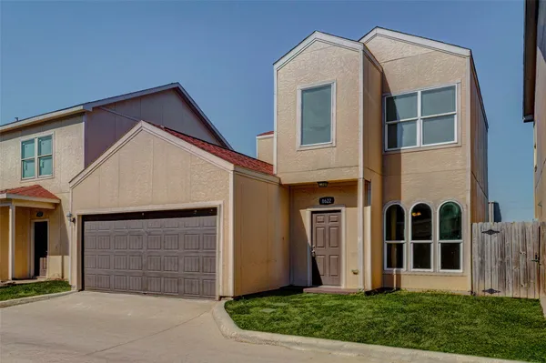 a view of a house with brick walls and a yard