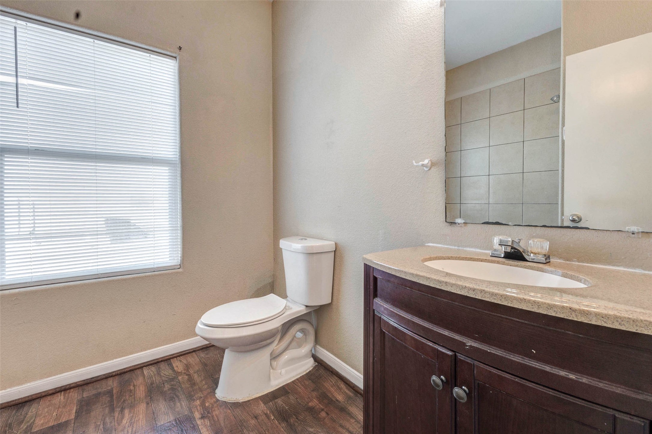 8622 Torcello Street Houston, TX 77031 - Photo 20 of 28 a bathroom with a granite countertop toilet a sink and a mirror