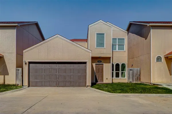 a front view of a house with a garden and garage