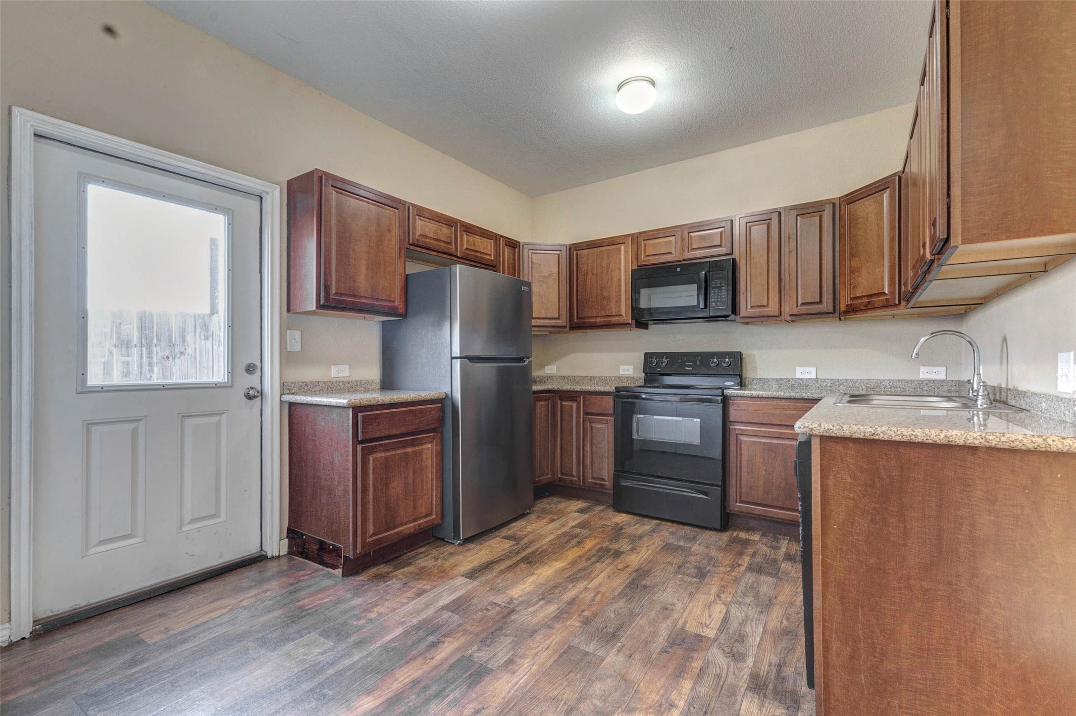 8622 Torcello Street Houston, TX 77031 - Photo 4 of 28 a kitchen with granite countertop a refrigerator stove top oven and sink