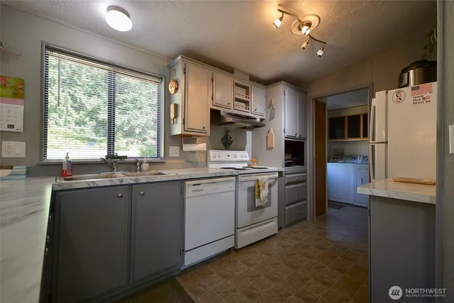 a kitchen with granite countertop a sink stainless steel appliances and cabinets