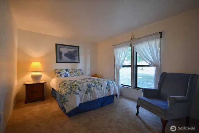 a spacious bedroom with a bed and a couch next to a window