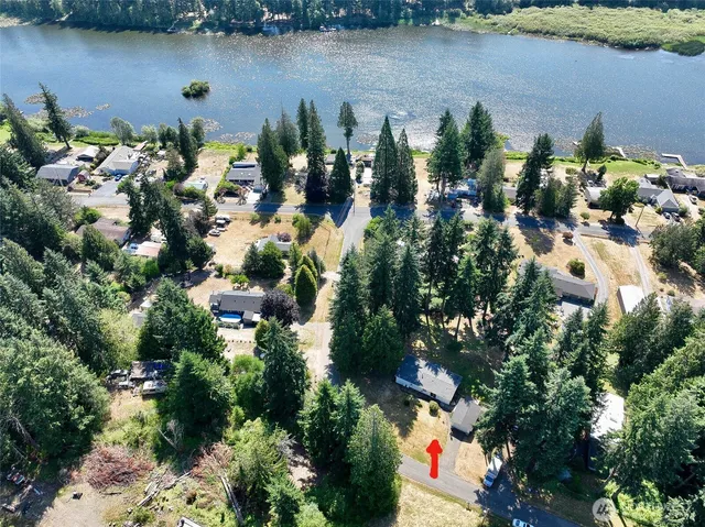 an aerial view of a house with a yard and lake view