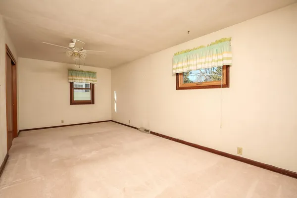 an empty room with a ceiling fan and a window