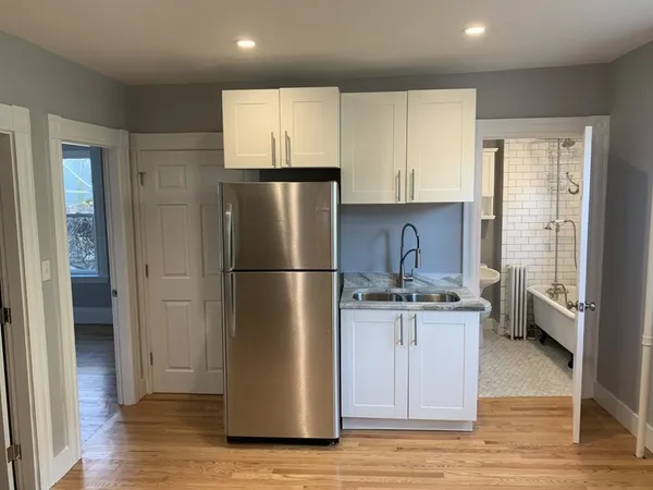 a kitchen with a refrigerator a sink and cabinets