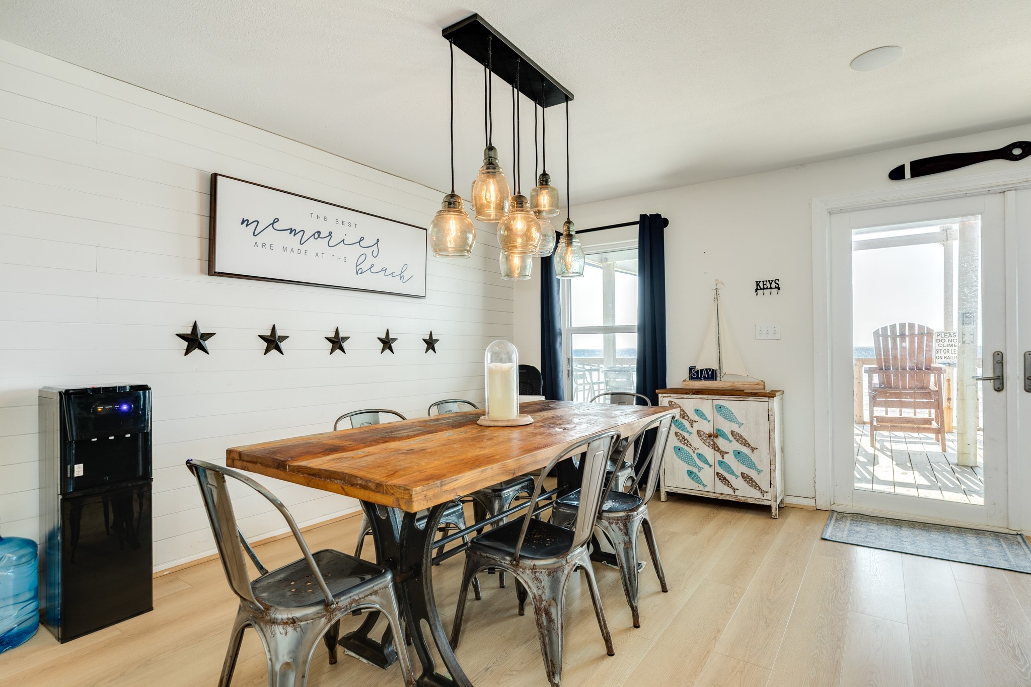 210 Beach Drive Surfside Beach, TX 77541 - Photo 8 of 33 Dining – Feature Wall – Shiplap accent wall and glass pendant cluster set a warm tone next to the deck entry for easy mealtime flow.