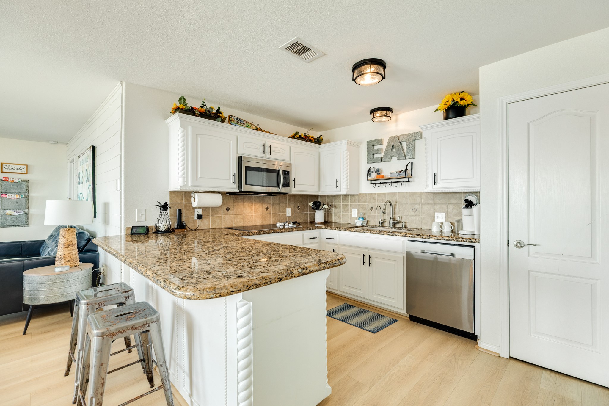 210 Beach Drive Surfside Beach, TX 77541 - Photo 10 of 33 Kitchen – Peninsula Seating – Bright U-shaped kitchen with granite counters, tile backsplash, stainless dishwasher, and peninsula seating for casual meals.