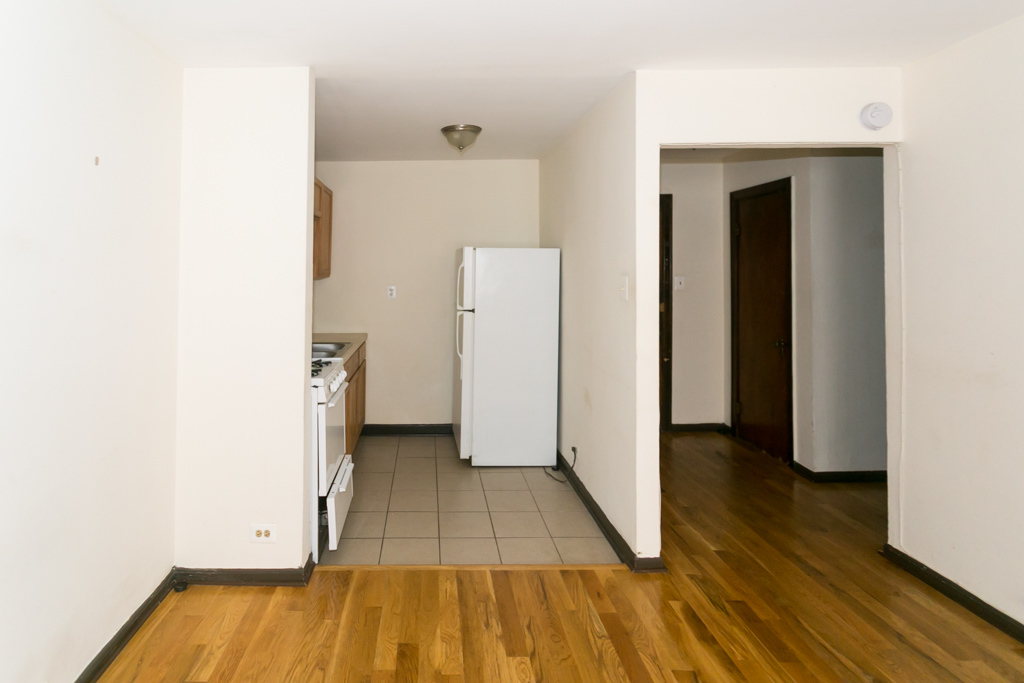 1211 West Elmdale Avenue, Unit 3 Chicago, IL 60660 - Photo 4 of 16 a view of a room with wooden floor and cabinets