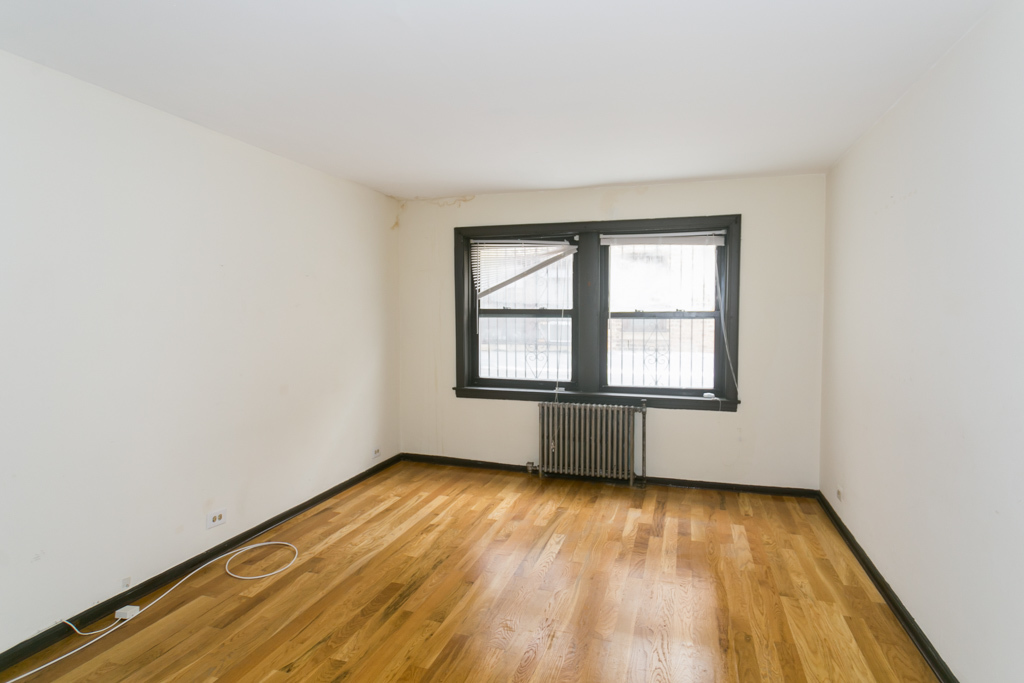 1211 West Elmdale Avenue, Unit 3 Chicago, IL 60660 - Photo 5 of 16 an empty room with wooden floor and windows