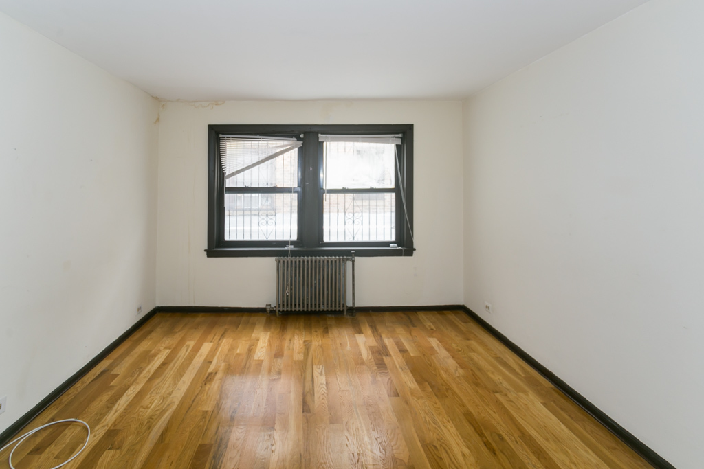 1211 West Elmdale Avenue, Unit 3 Chicago, IL 60660 - Photo 6 of 16 an empty room with wooden floor and windows