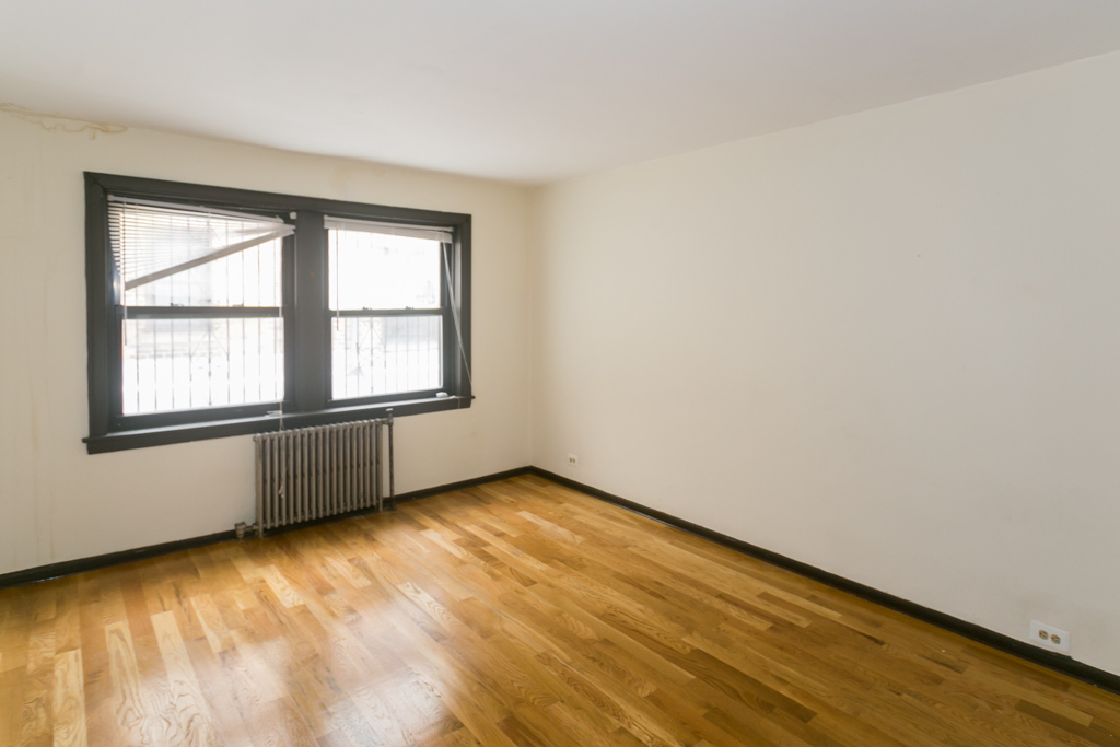 1211 West Elmdale Avenue, Unit 3 Chicago, IL 60660 - Photo 7 of 16 an empty room with wooden floor and windows