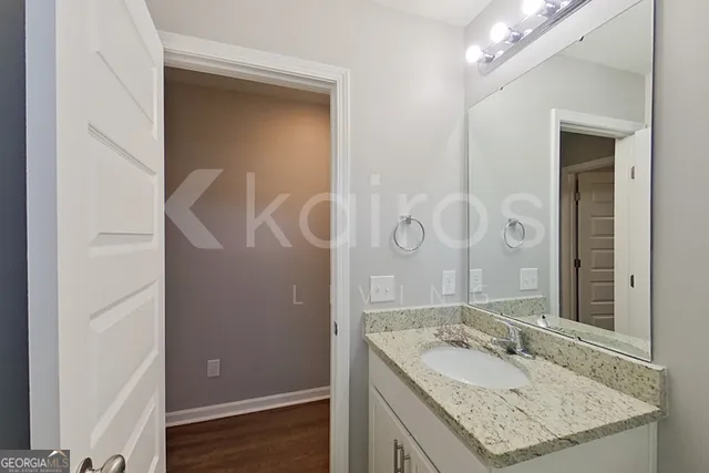 a bathroom with a granite countertop sink and a mirror