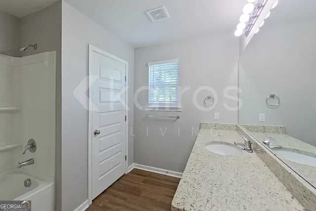 a spacious bathroom with a granite countertop sink a toilet and shower