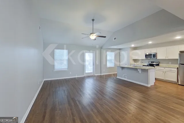 a view of kitchen with granite countertop cabinets stove and wooden floor
