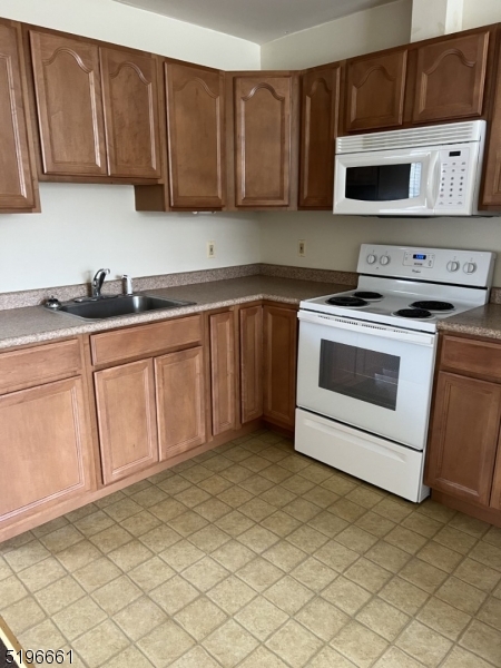 1483 Union Valley Road West Milford, NJ 07480 - Photo 4 of 7 a kitchen with stainless steel appliances granite countertop a stove a sink and a microwave