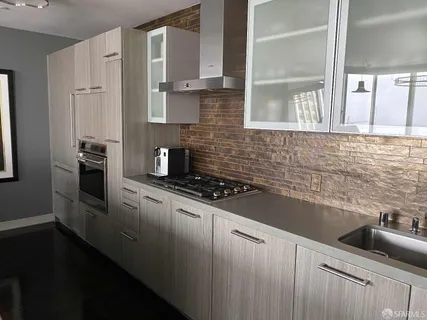 a kitchen with granite countertop a sink stove and refrigerator