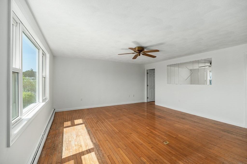 12 Crestview Terrace Gloucester, MA 01930 - Photo 6 of 27 a view of an empty room with a window and wooden floor