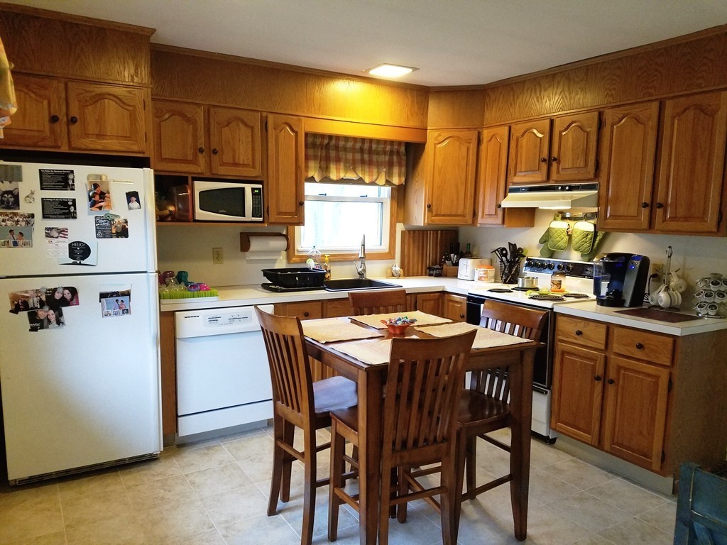 34 Higgins Street Springfield, MA 01108 - Photo 5 of 15 a kitchen with a table chairs refrigerator and cabinets
