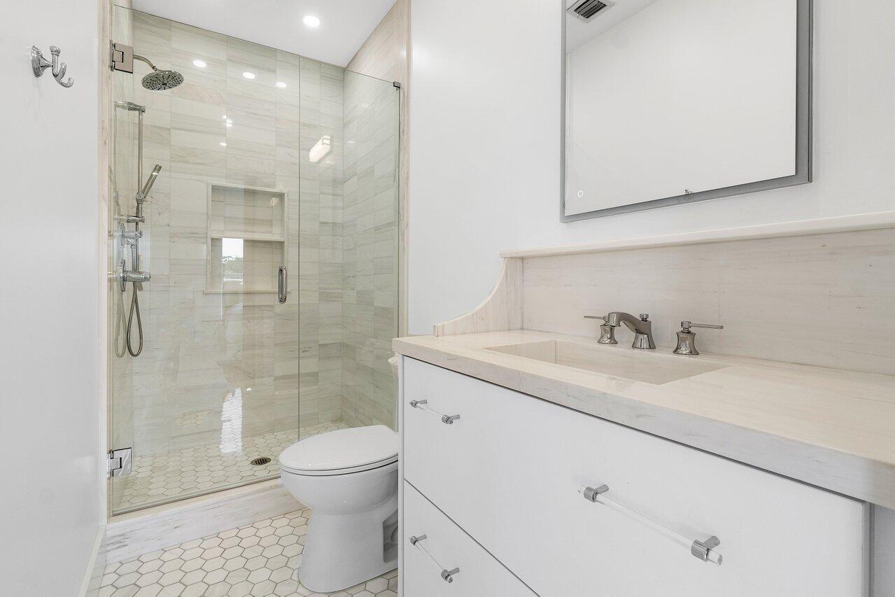 1366 Southwest 4th Court Boca Raton, FL 33432 - Photo 30 of 43 a bathroom with a toilet sink vanity granite and shower