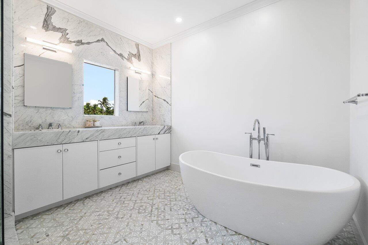 1366 Southwest 4th Court Boca Raton, FL 33432 - Photo 36 of 43 a bathroom with a white tub a sink and mirror