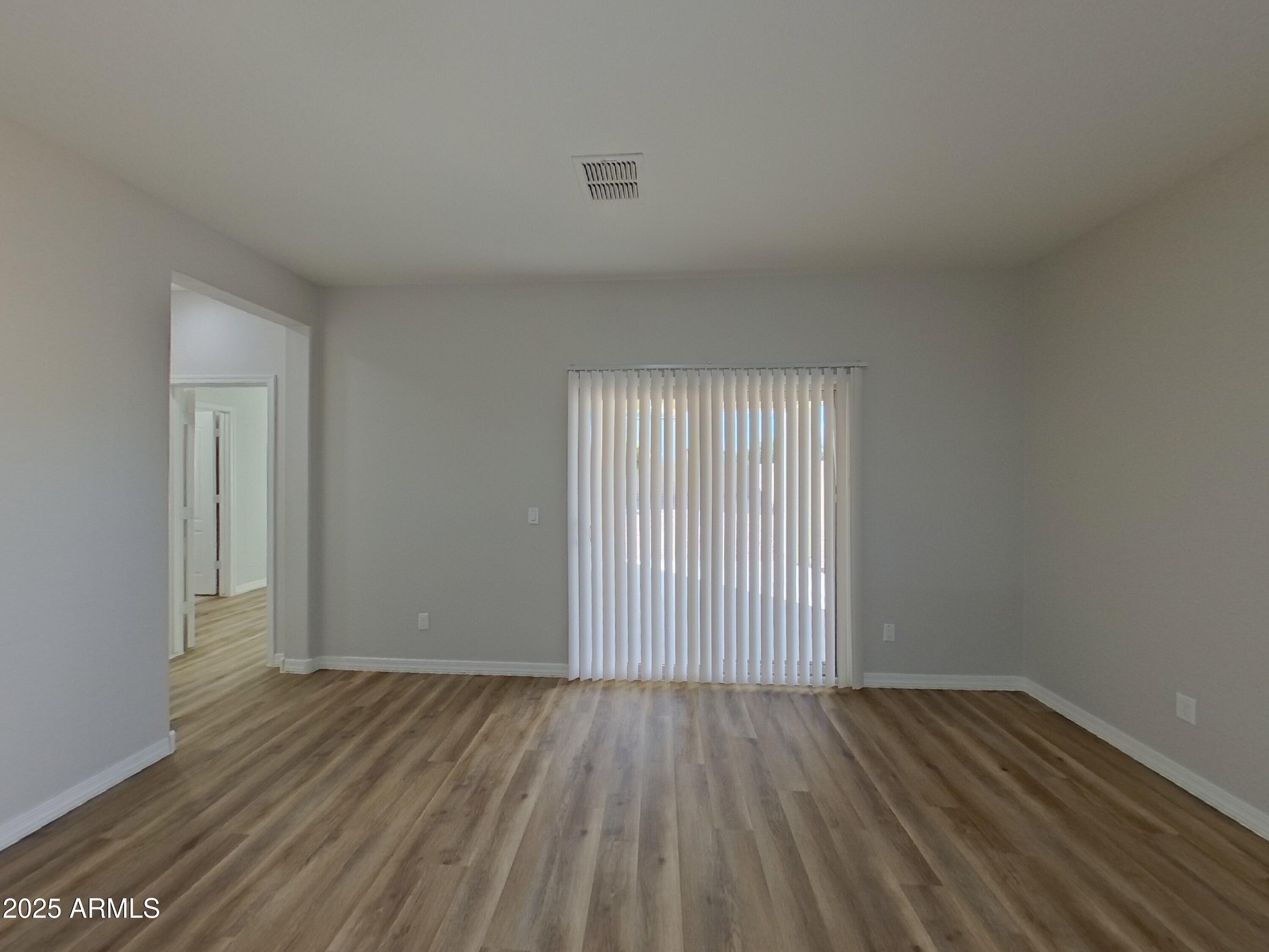 40209 Walker Way Maricopa, AZ 85138 - Photo 2 of 16 an empty room with wooden floor