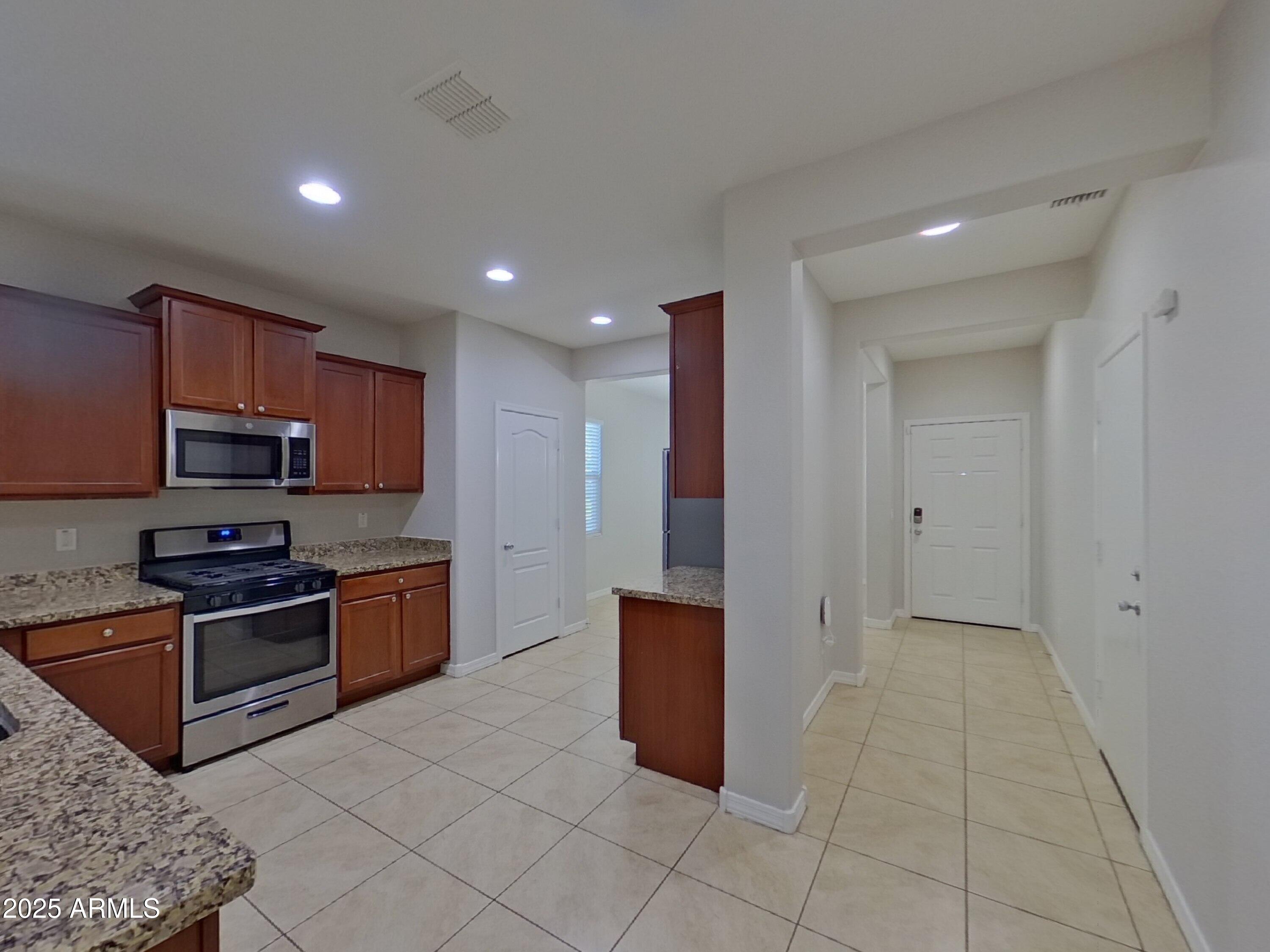 40209 Walker Way Maricopa, AZ 85138 - Photo 5 of 16 a kitchen with stainless steel appliances granite countertop a refrigerator and a stove top oven