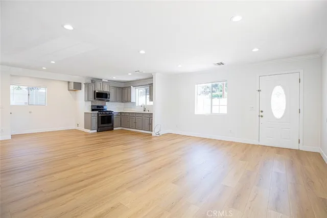 a view of empty room with wooden floor and window