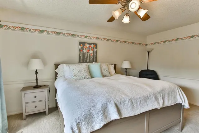 a bedroom with a large bed and a chandelier