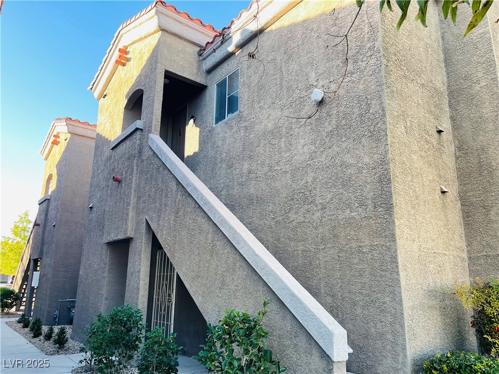 View of property exterior with stucco siding and a tile roof