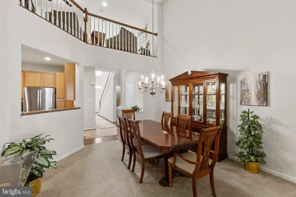 a living room with furniture a chandelier and a dining table