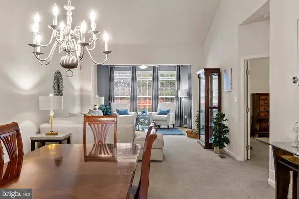 a view of a hallway with dining room and wooden floor