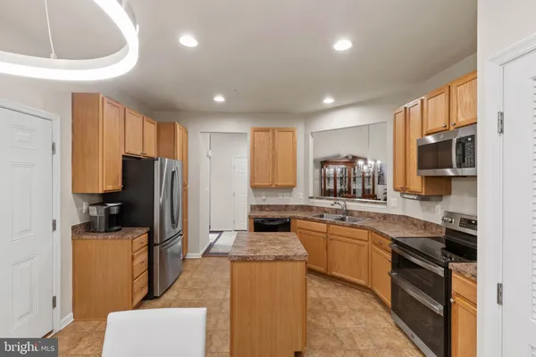 a kitchen with stainless steel appliances granite countertop a stove top oven a sink dishwasher a refrigerator and a microwave